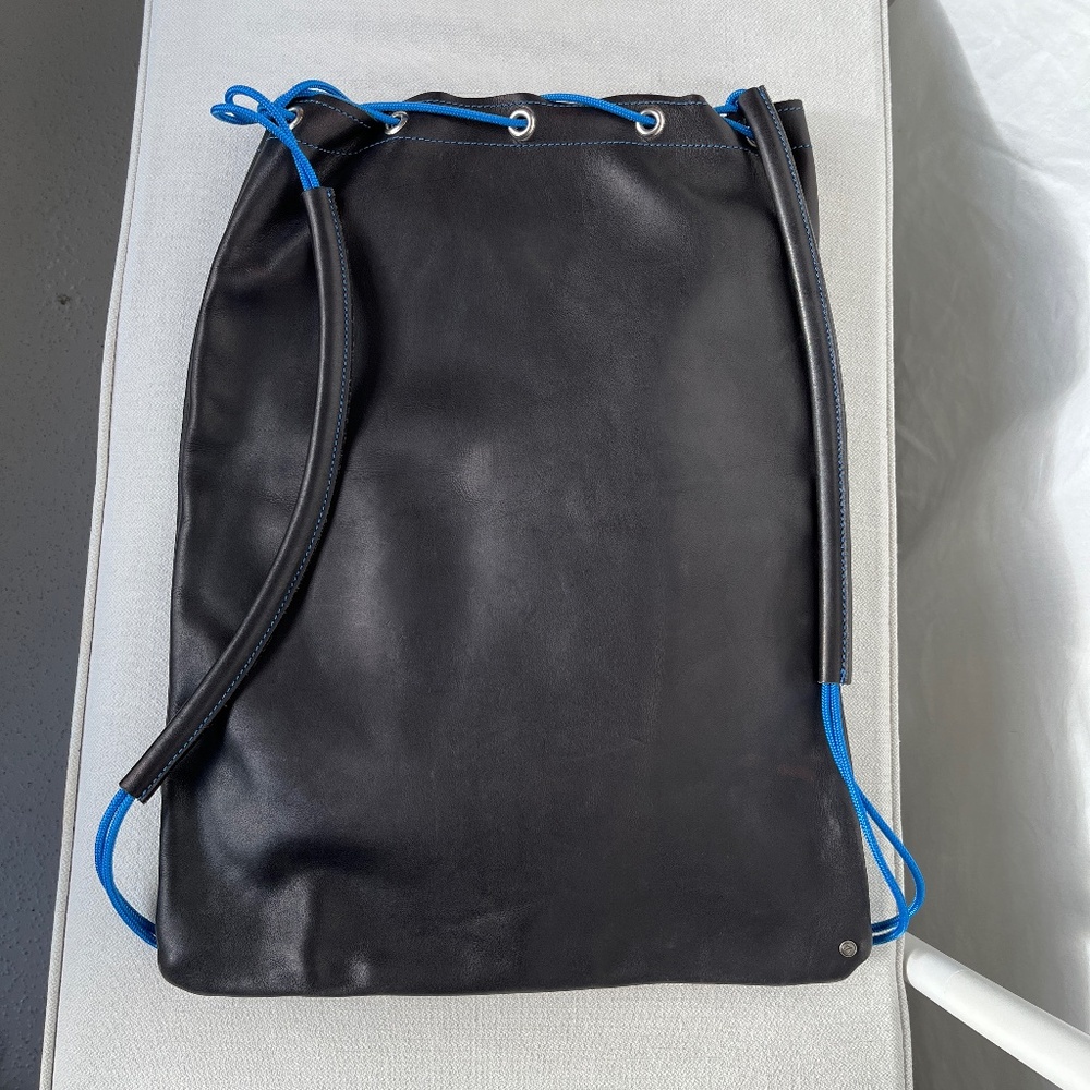 Sleek, genuine leather backpack, with bright blue cords, 20 x 15 in